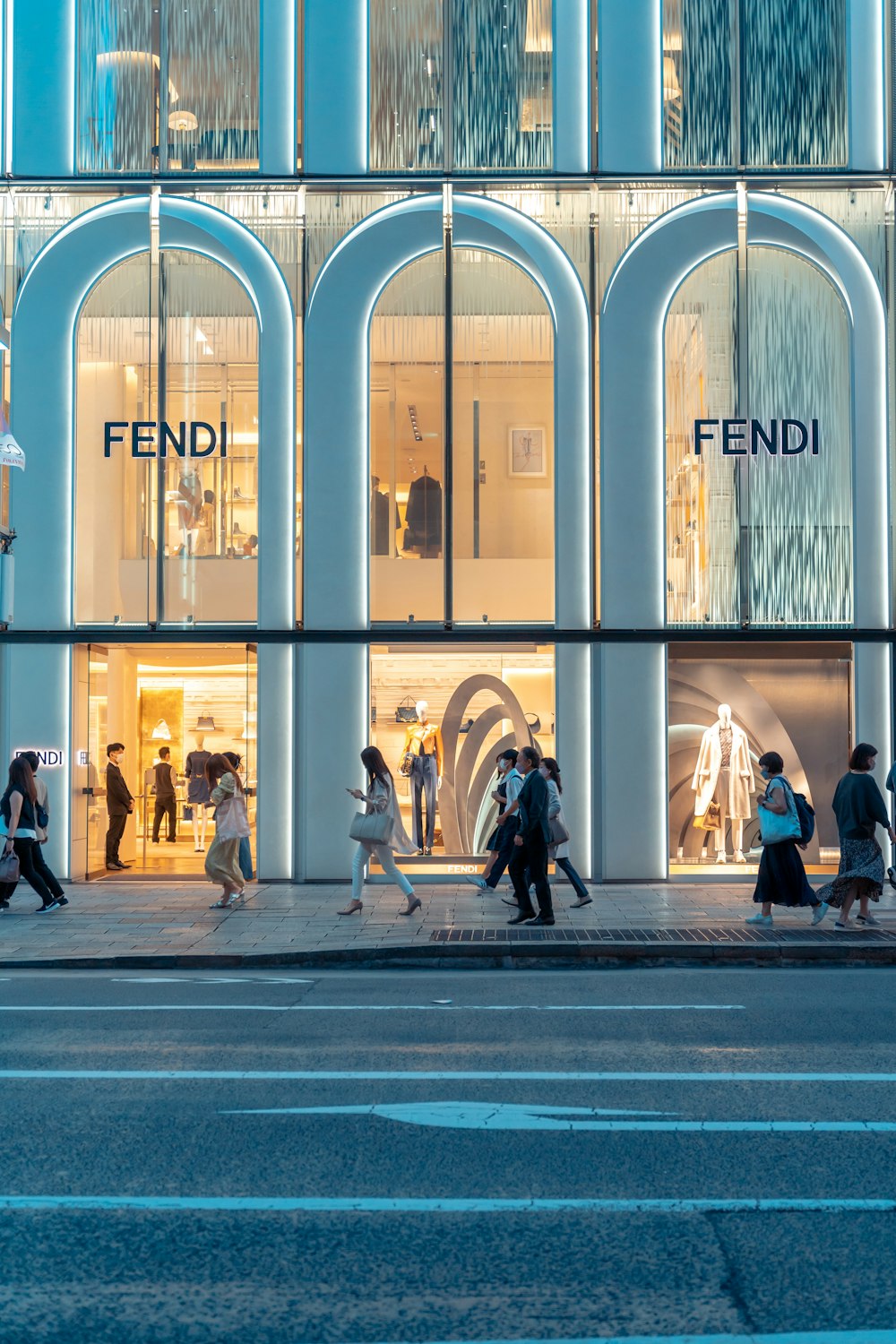 a group of people walking past a tall building