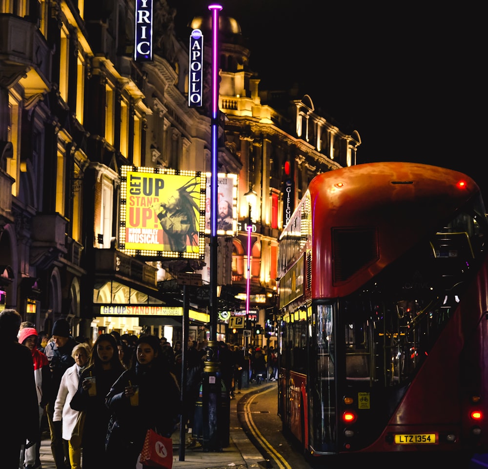 a red double decker bus driving down a street