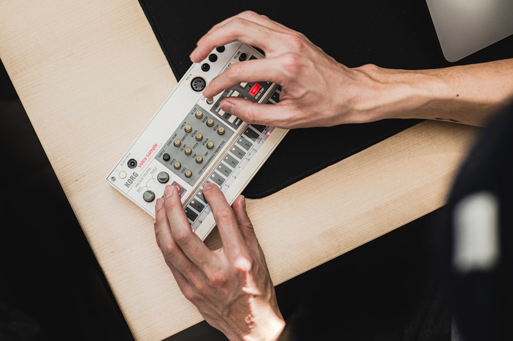 a person using a remote control on a table