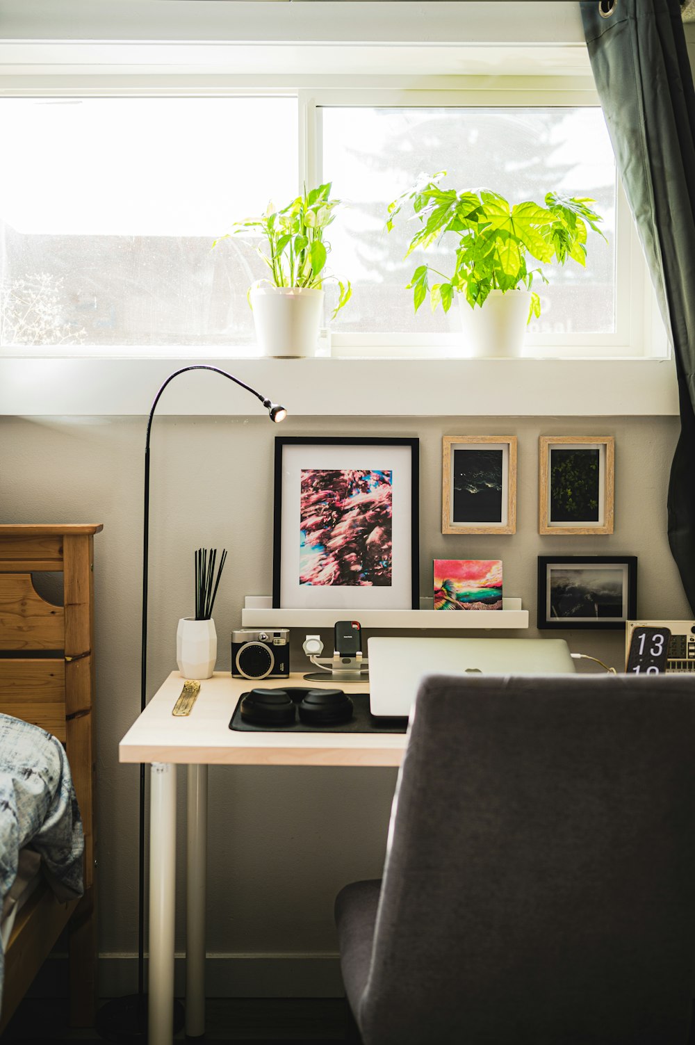 a desk with a laptop computer and a plant on top of it