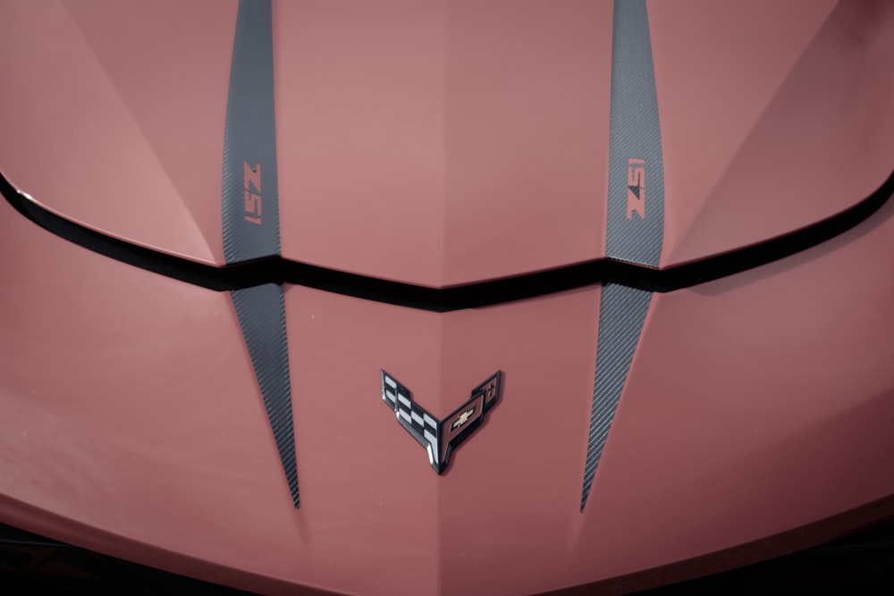 a close up of the hood of a pink car