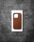 Textured green Caseogen case on an iPhone 15 Pro Max, resting on a wooden table.