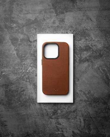 A neutral pastel-colored phone case resting on a soft surface.