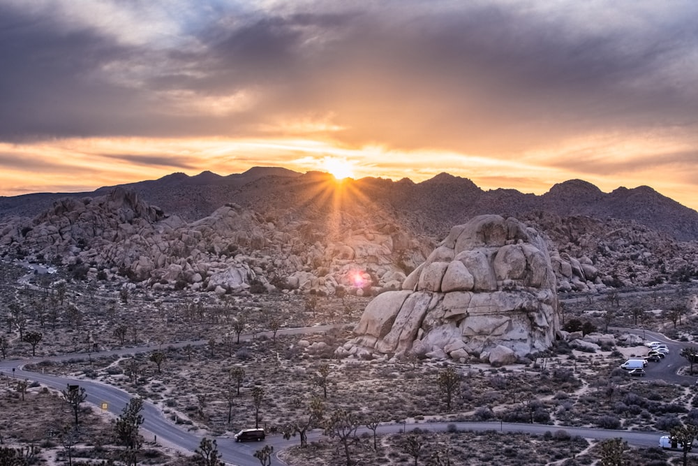 the sun is setting over the mountains in the desert