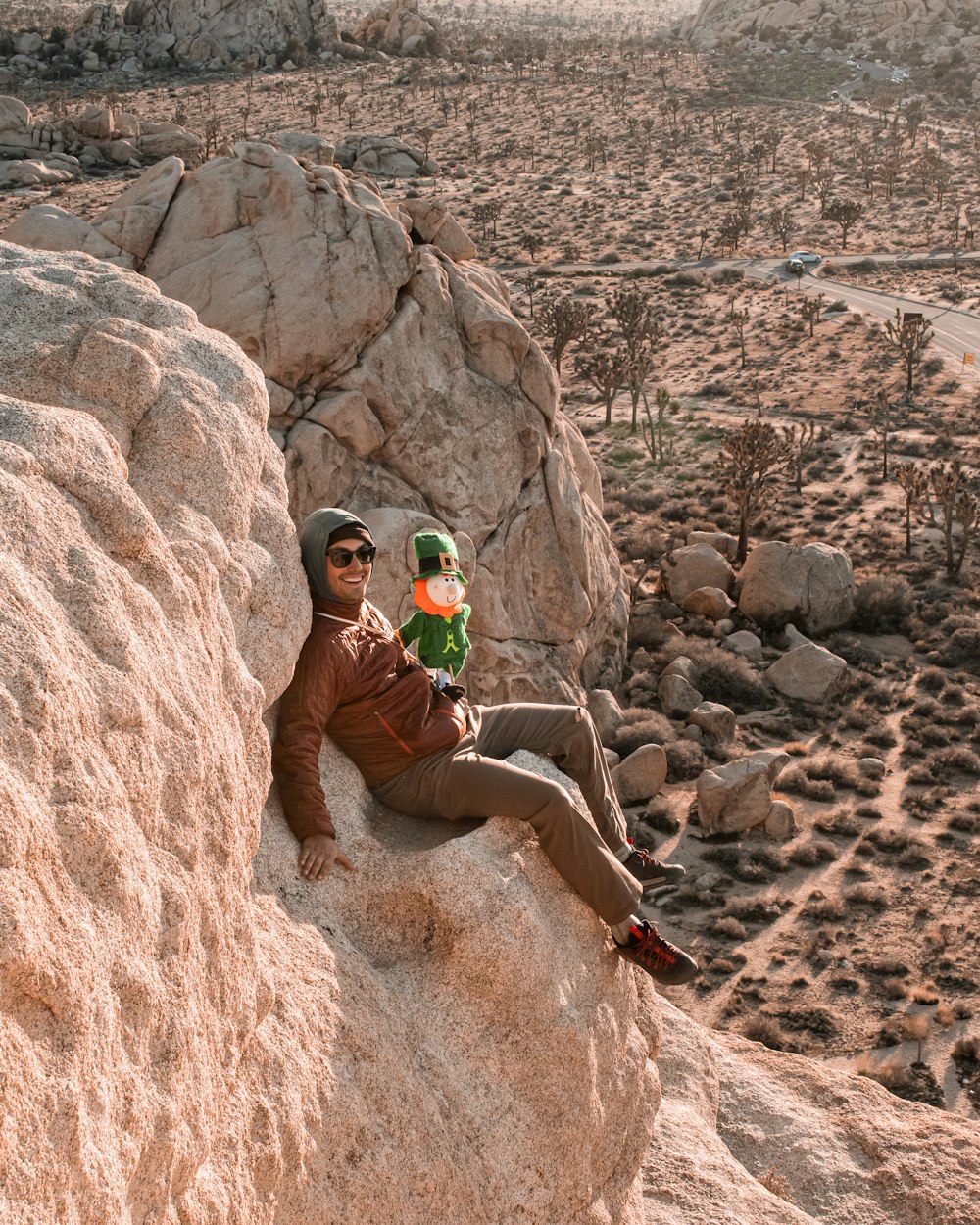 a man sitting on top of a large rock