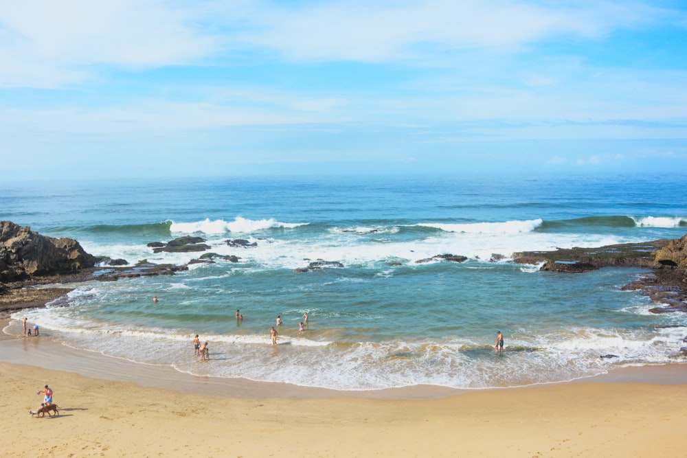 a group of people standing on top of a sandy beach