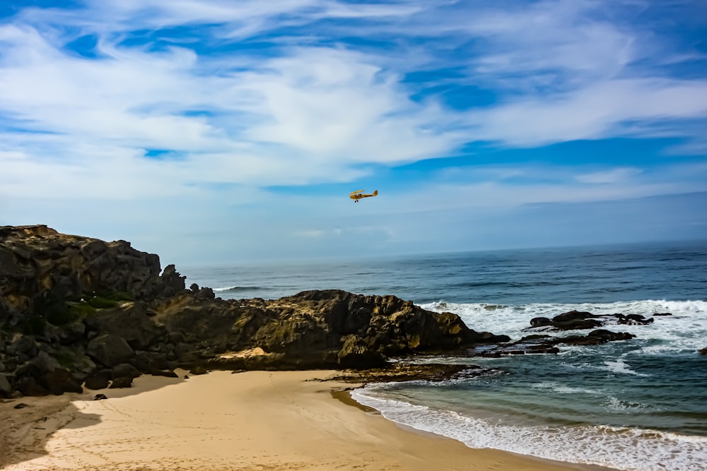 a plane is flying over the ocean on a sunny day