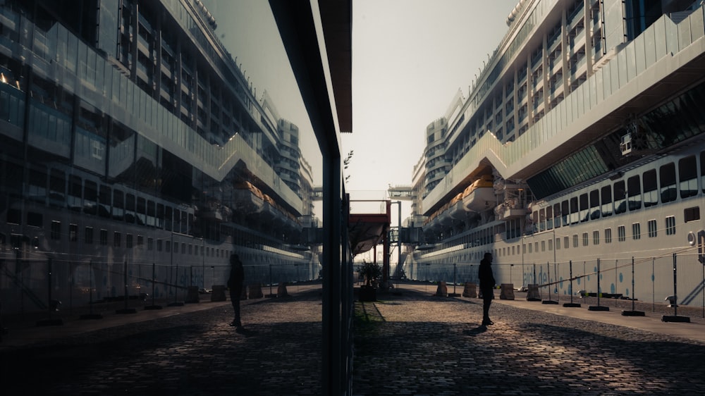 a man walking down a street next to tall buildings