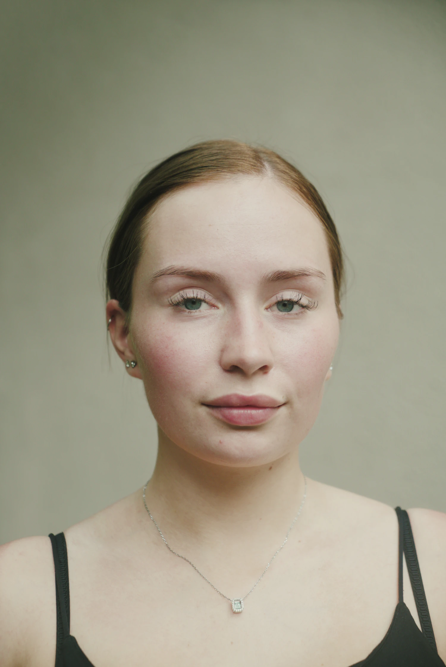 Portrait of a young woman against a soft green background