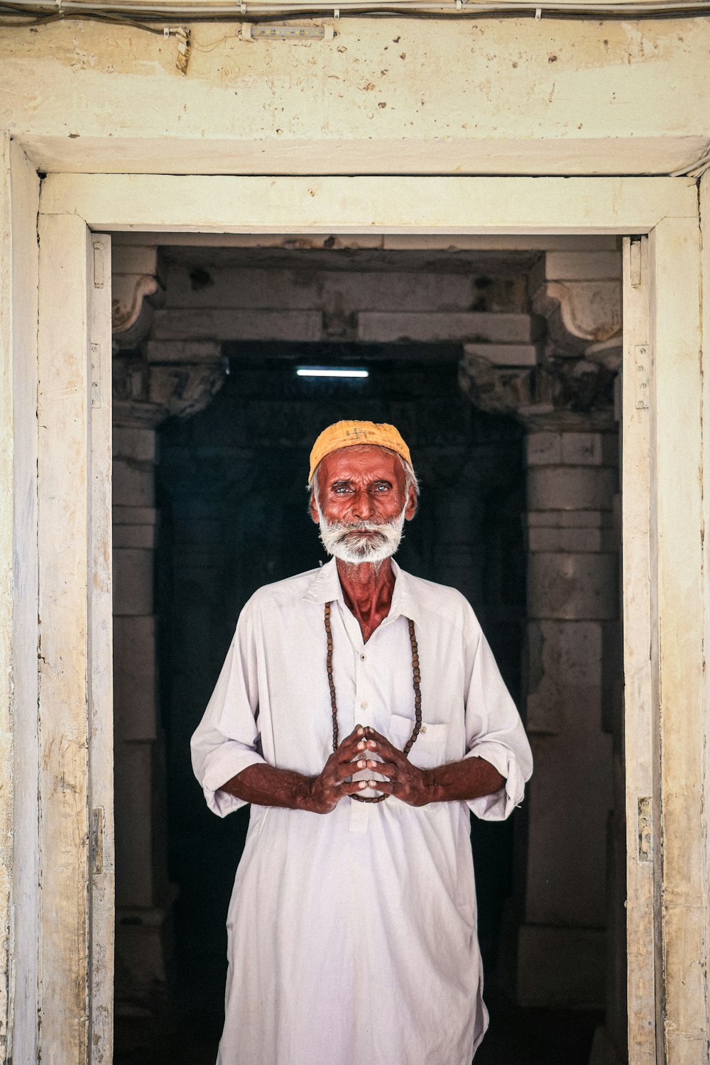 a man standing in a doorway with his hands crossed