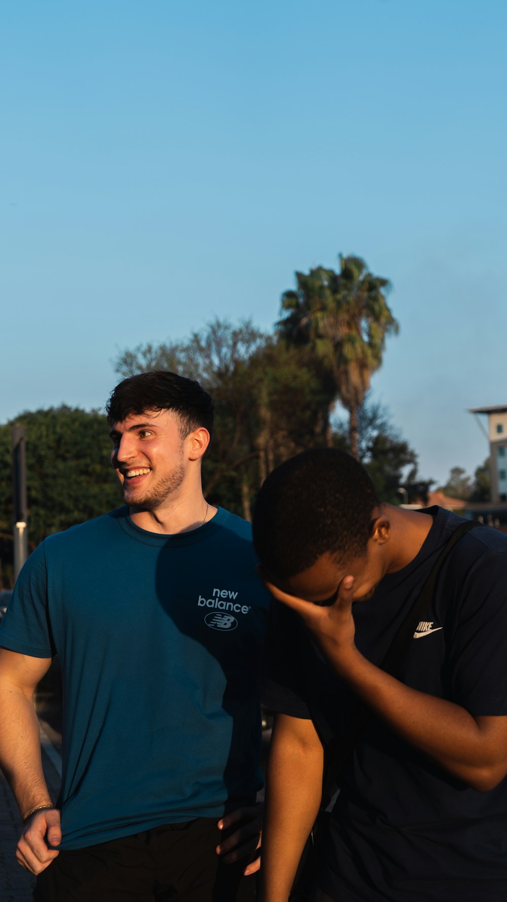 two men standing next to each other in a parking lot