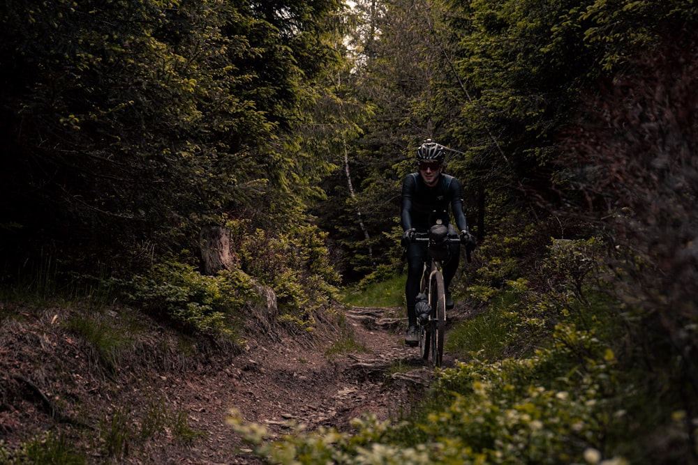 a man riding a bike down a dirt road