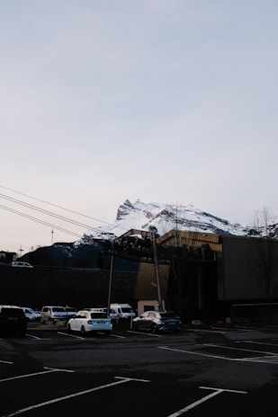 A secure parking lot with mountain views and a small rustic shop in the background.