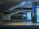 A wide-angle shot of a busy Pune railway station entrance featuring dynamic LED ads attracting commuters.
