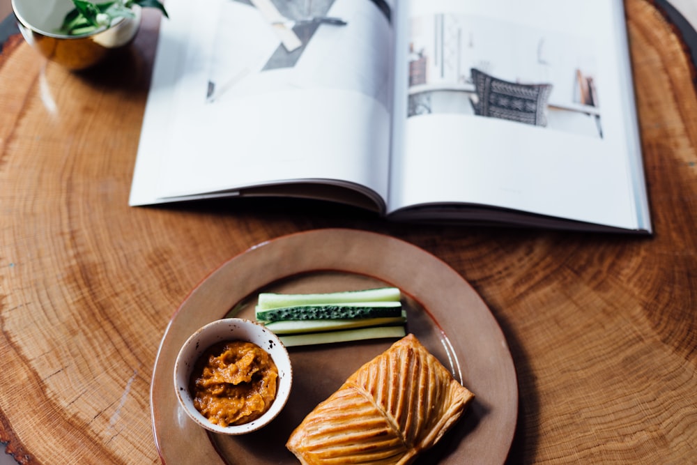 a plate of food on a table with an open book