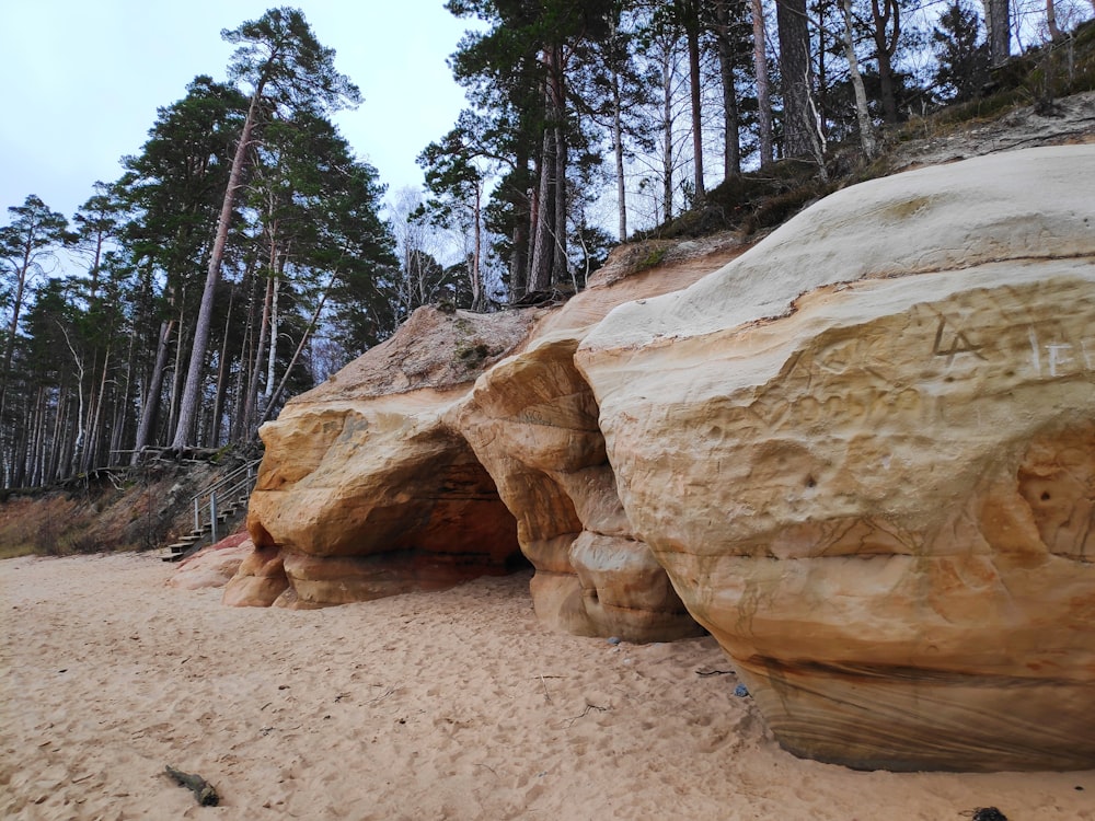 a group of large rocks sitting on top of a sandy beach