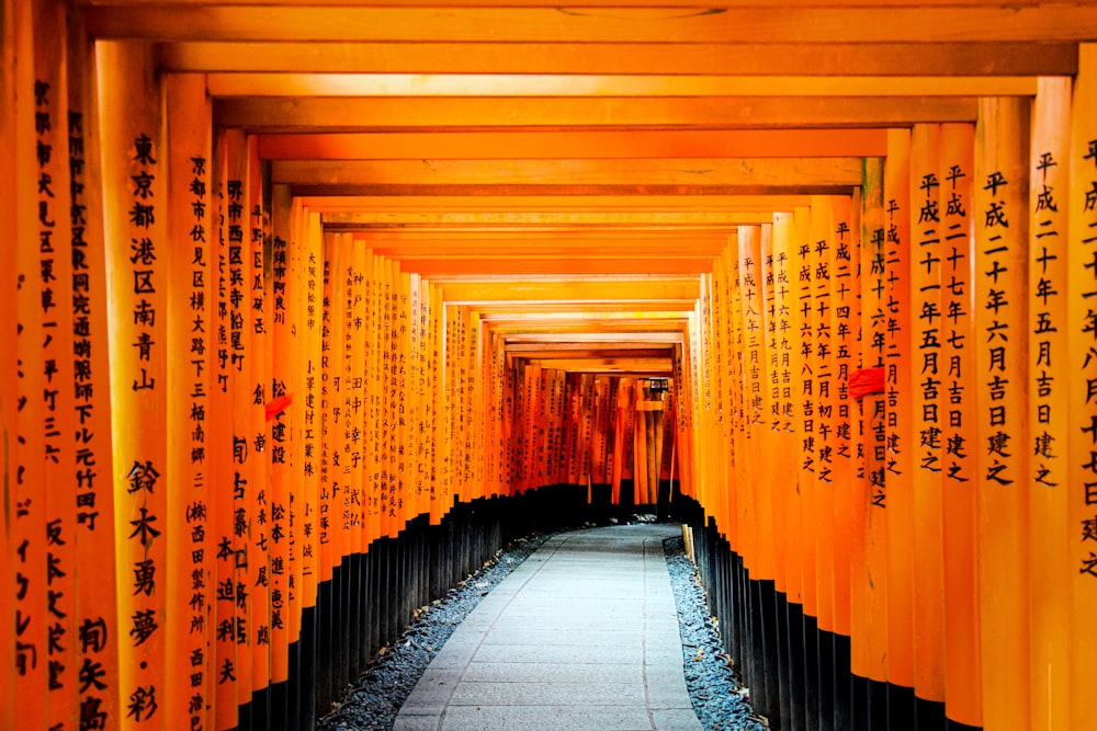 a walkway lined with orange and black columns