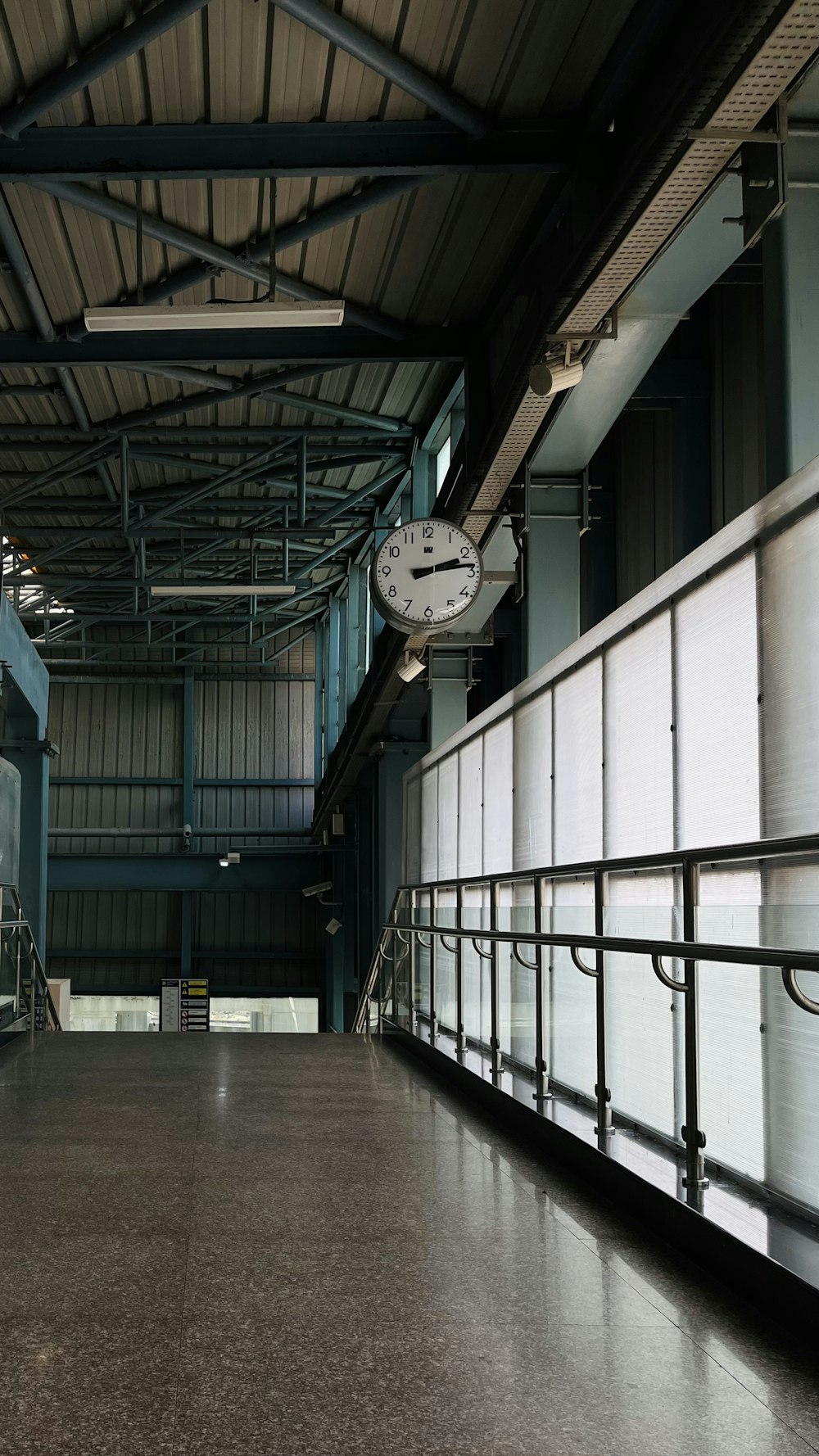 a clock hanging from the ceiling of a building