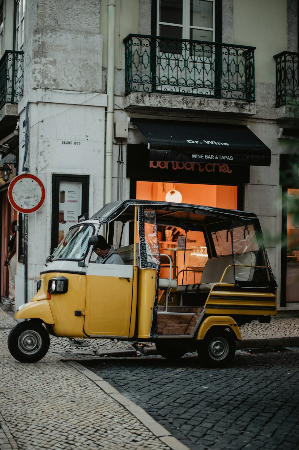 a small yellow and white car parked in front of a building