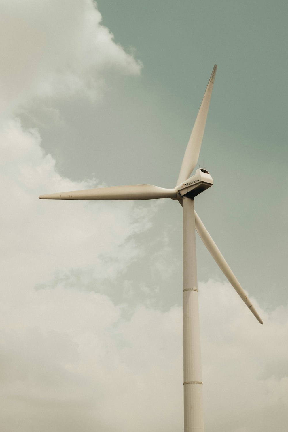 a wind turbine is shown against a cloudy sky