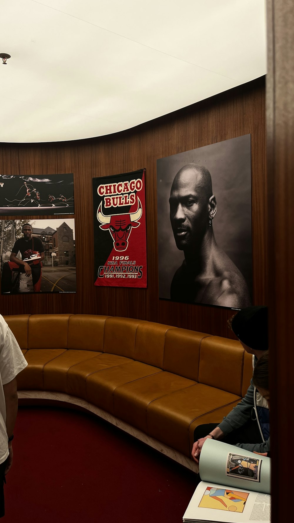 a man standing in front of a booth with posters on the wall