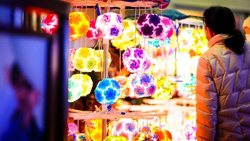 a woman standing in front of a display of colorful lights