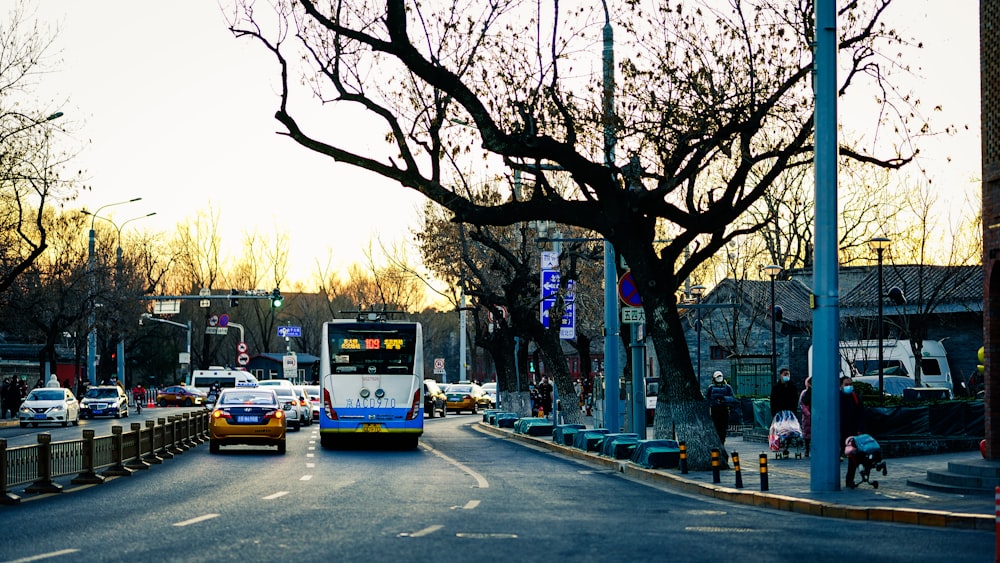 a blue and white bus driving down a street