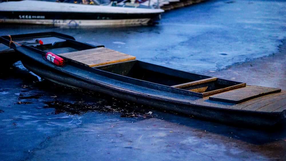 a small boat sitting on top of a frozen lake