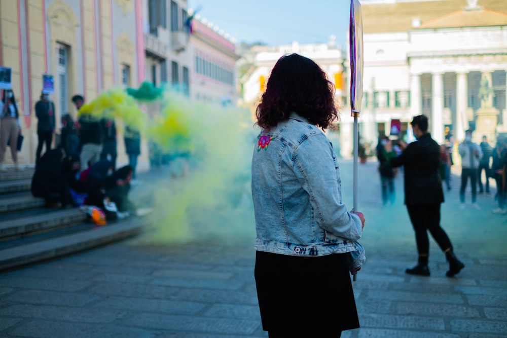 a woman holding a flag in the middle of a street