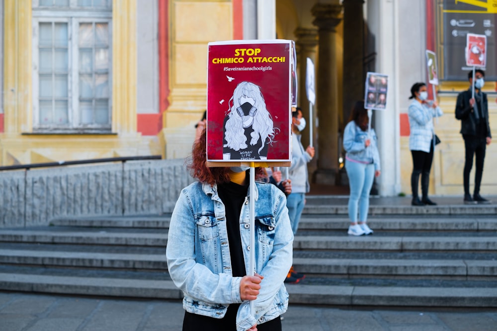 a woman holding a sign with a dog on it