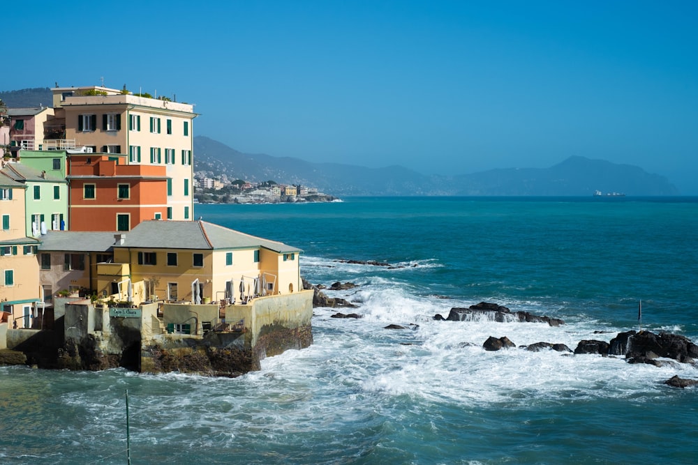 a group of buildings sitting on top of a cliff next to the ocean