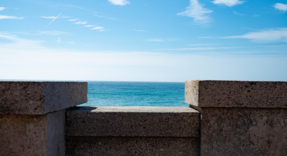 a view of the ocean from a stone wall