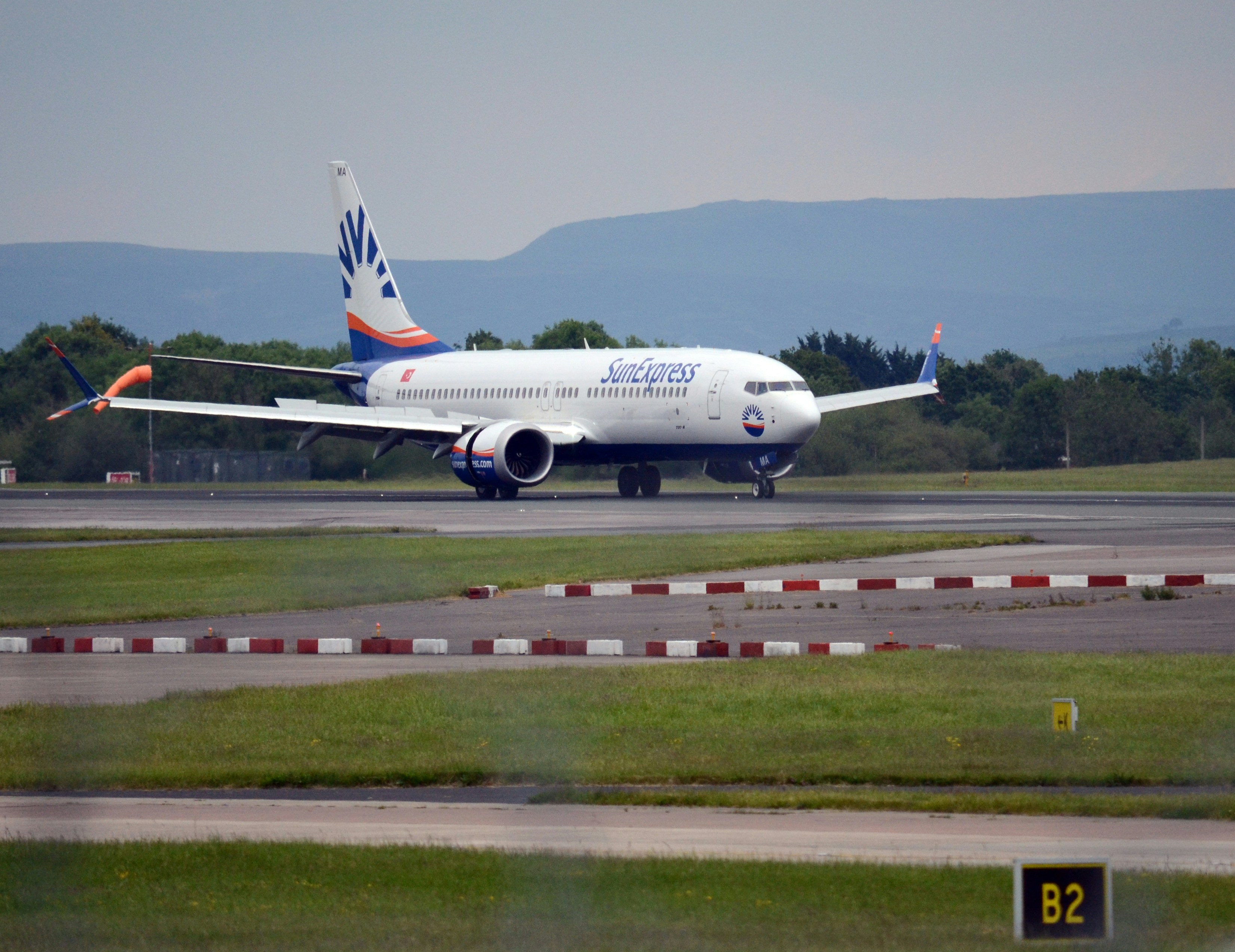 a large jetliner sitting on top of an airport runway, Planes landing/taking off at Manchester Airport, UK.