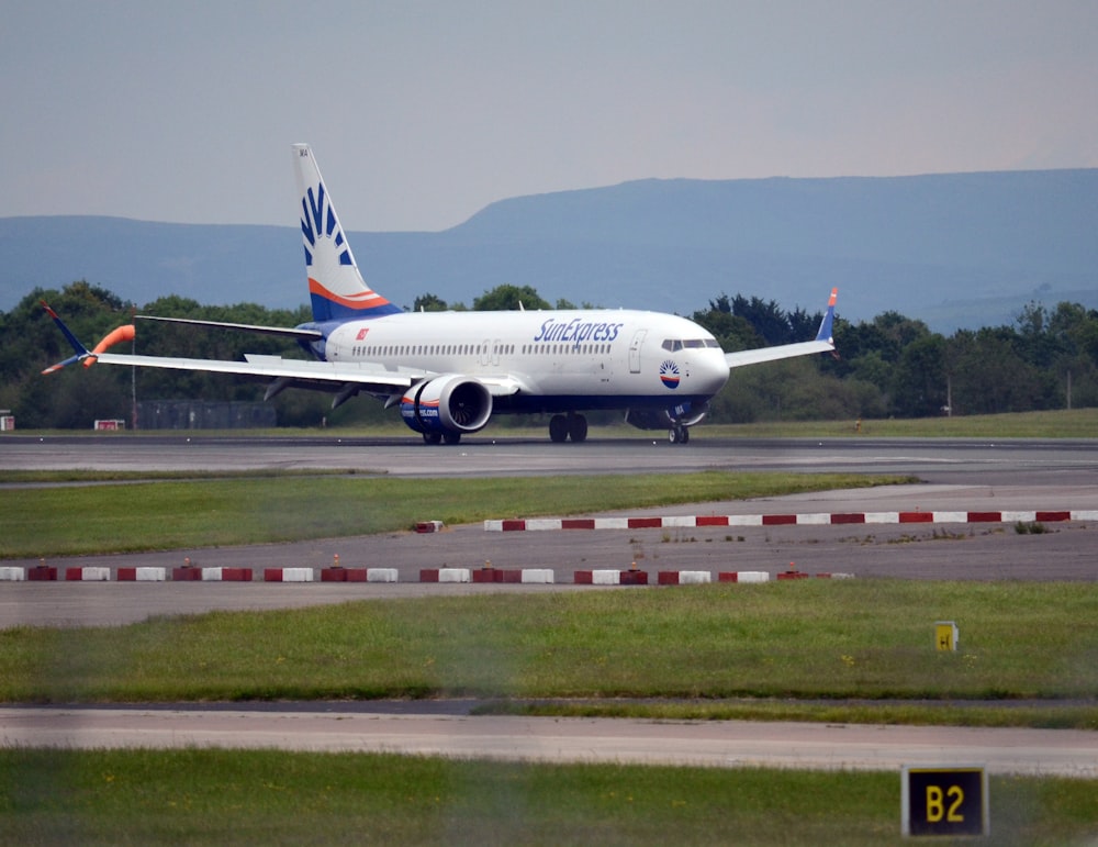 un grande aereo di linea seduto in cima a una pista dell'aeroporto