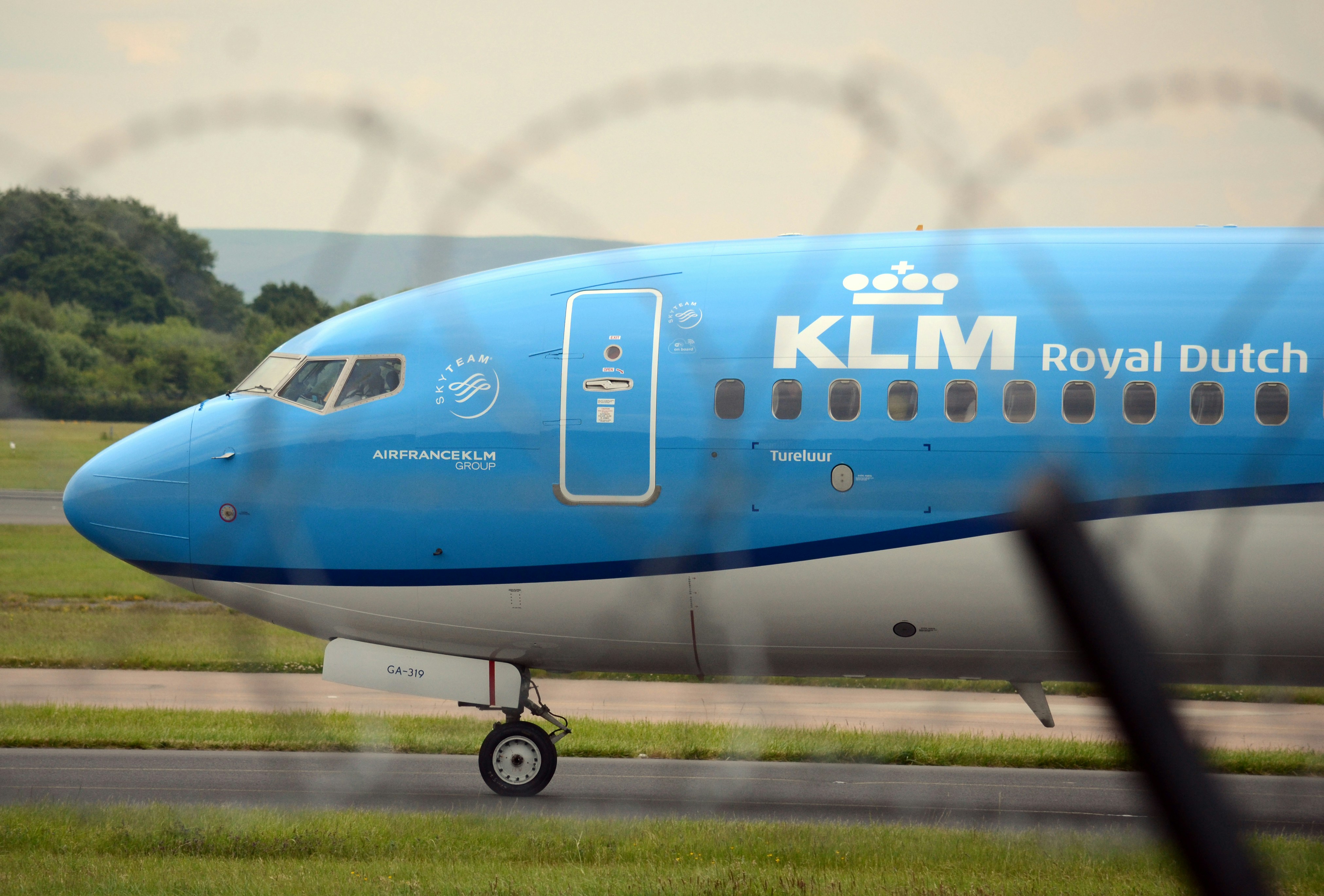 a blue and white plane is on the runway, Planes landing/taking off at Manchester Airport, UK.
