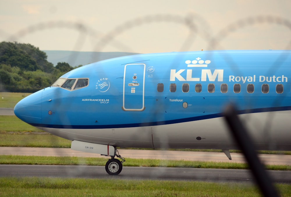 um avião azul e branco está na pista