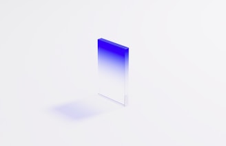 Close-up of a perfectly crafted glass block reflecting soft blue light.