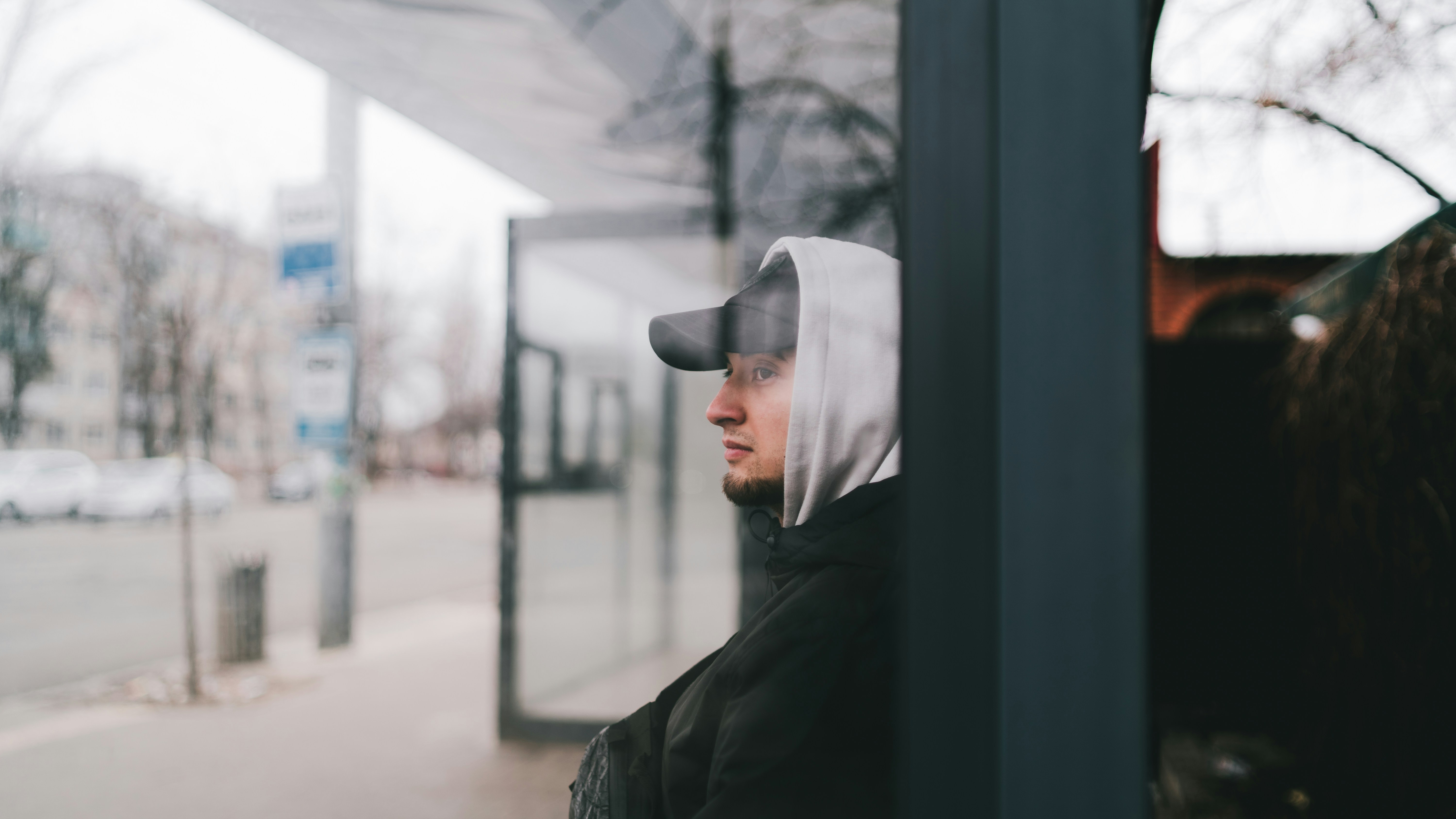 a man in a black jacket is looking out a window