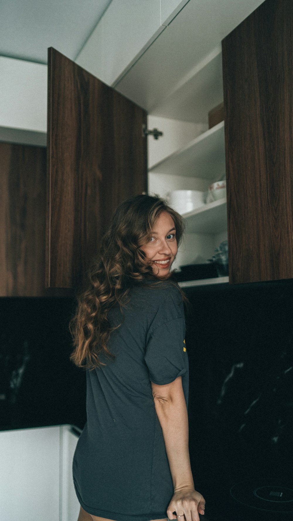 a woman standing in front of a stove in a kitchen