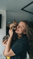 A close-up of a happy pet owner hugging their dog dressed in a playful, handcrafted outfit.