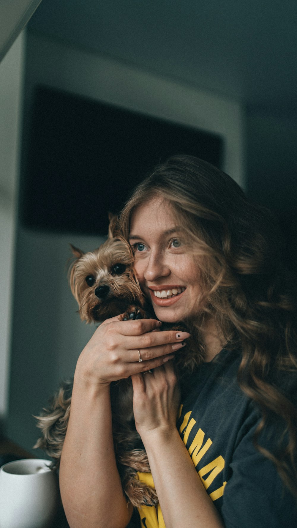 a woman holding a small dog in her arms