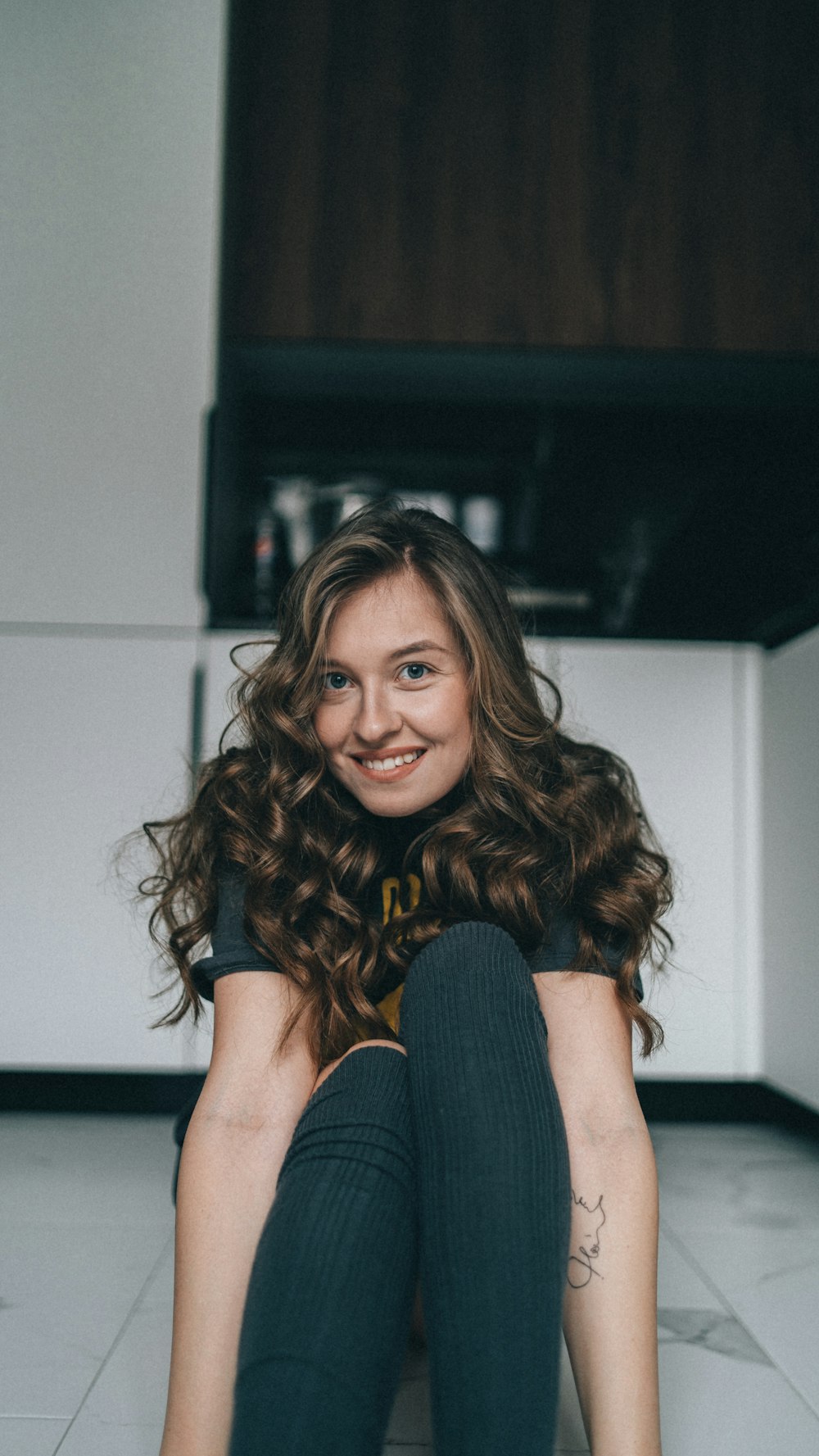 a woman sitting on the floor with her legs crossed