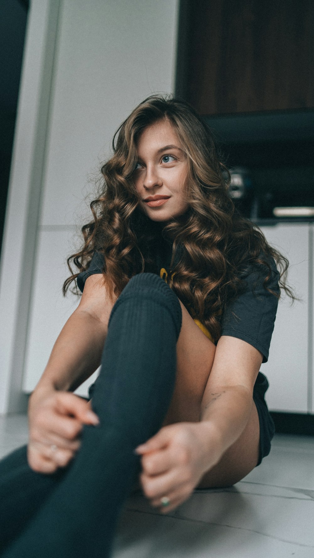 a woman sitting on the floor with her legs crossed