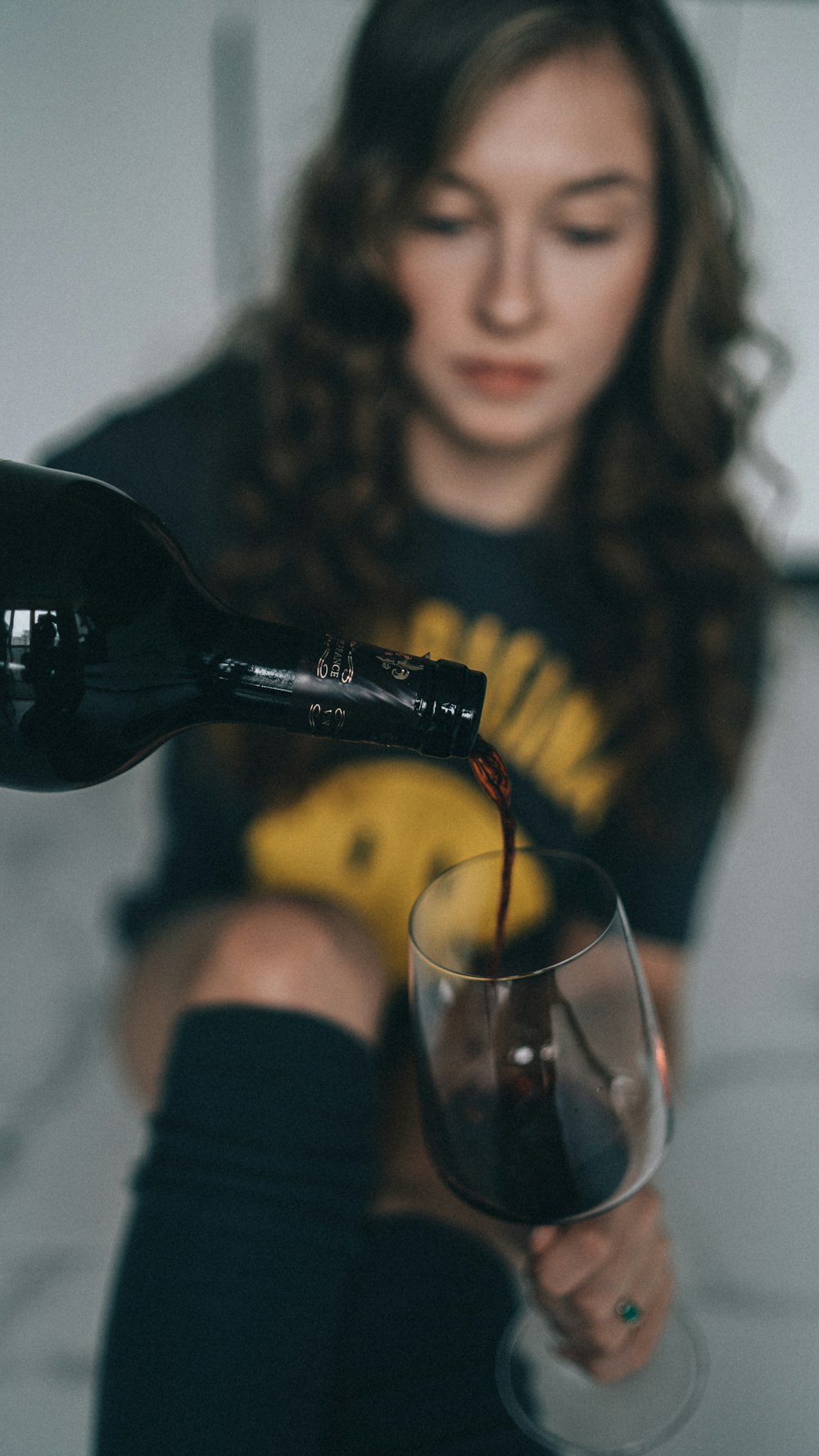 a woman is pouring a glass of wine