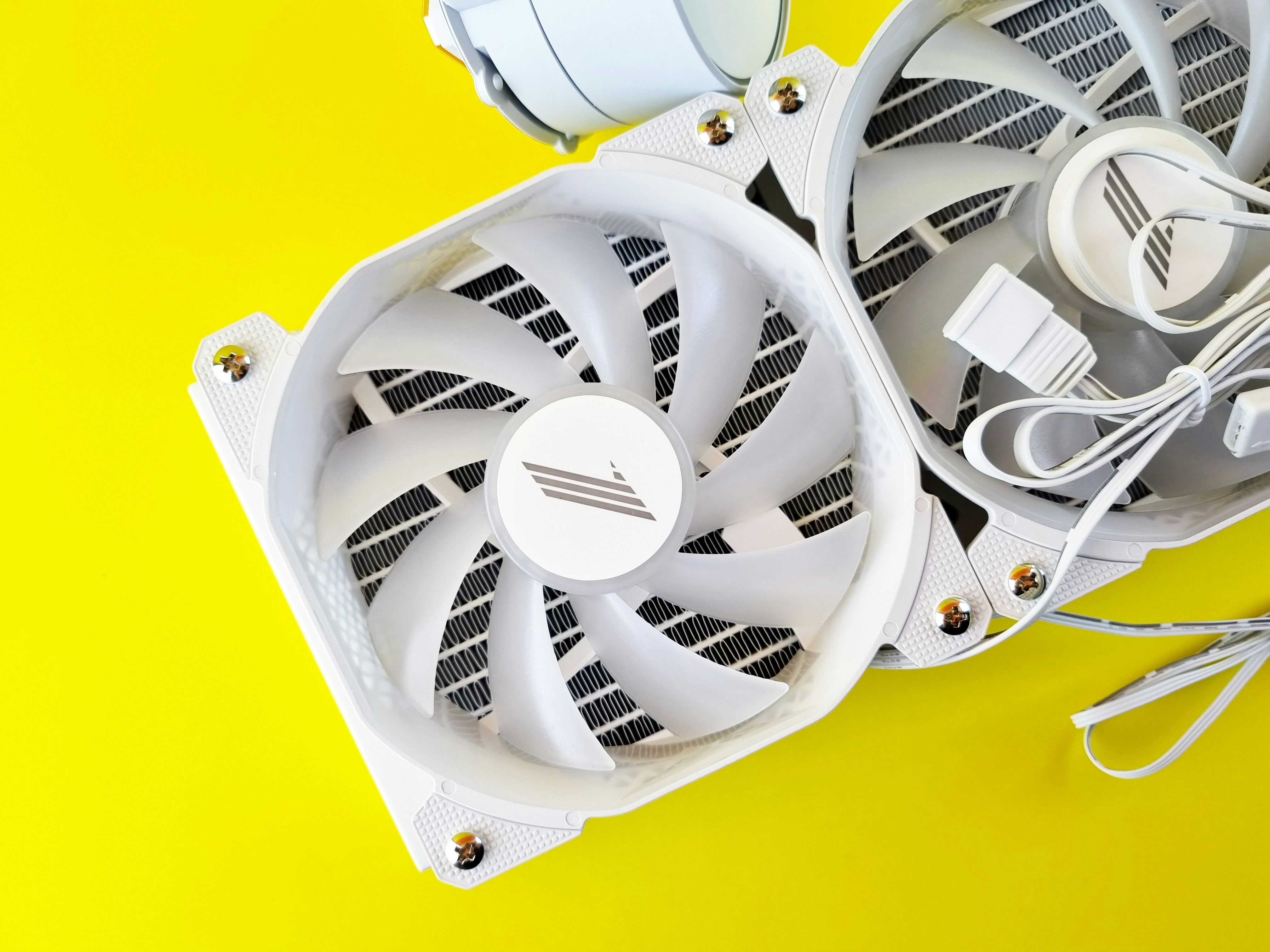 a white computer fan sitting on top of a yellow surface