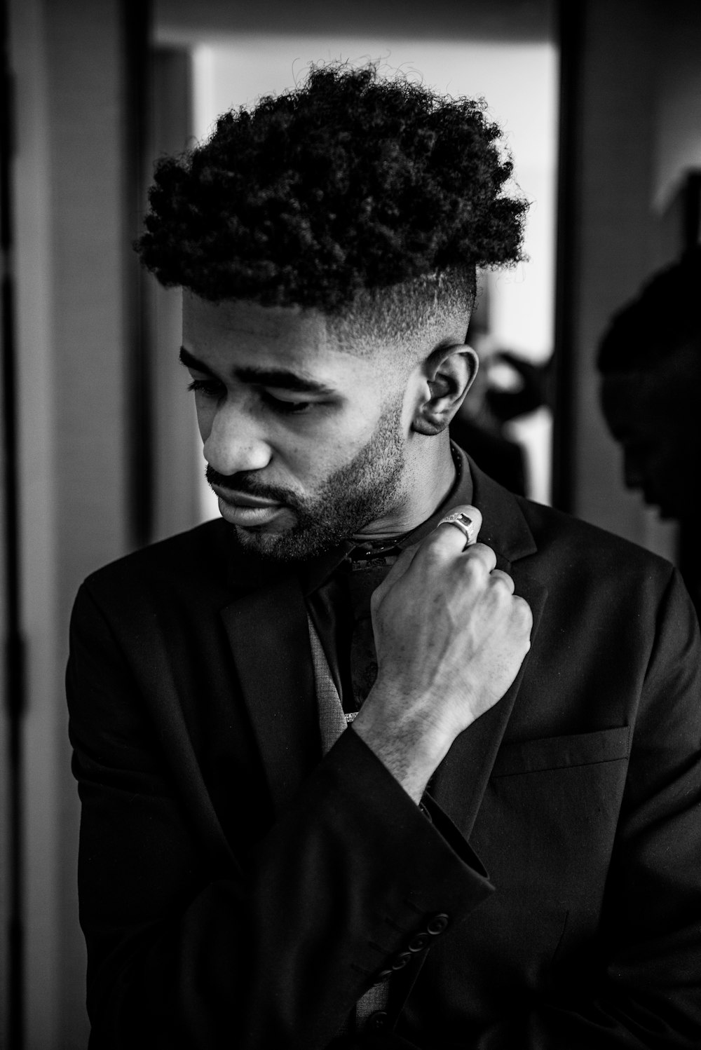 a man in a suit adjusting his tie