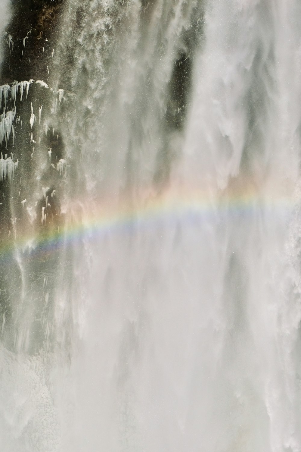 a rainbow in the middle of a waterfall