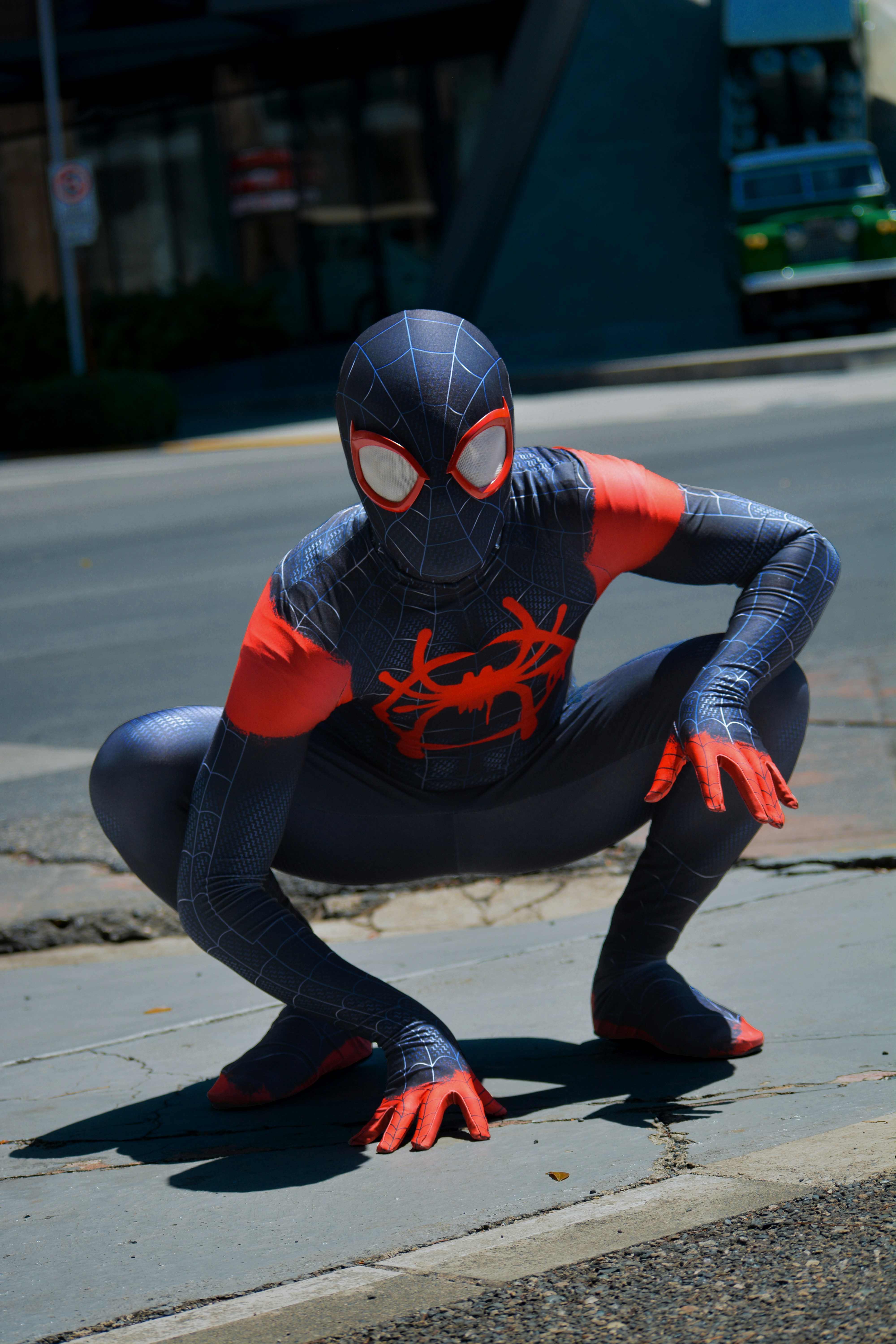 Seorang pria dengan setelan Spider Man berpose untuk berfoto