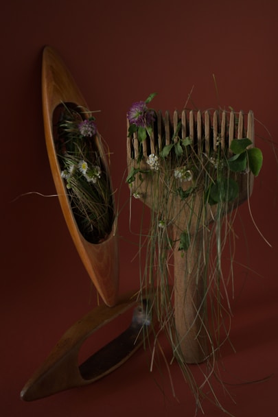 a wooden comb with flowers in it next to a planter