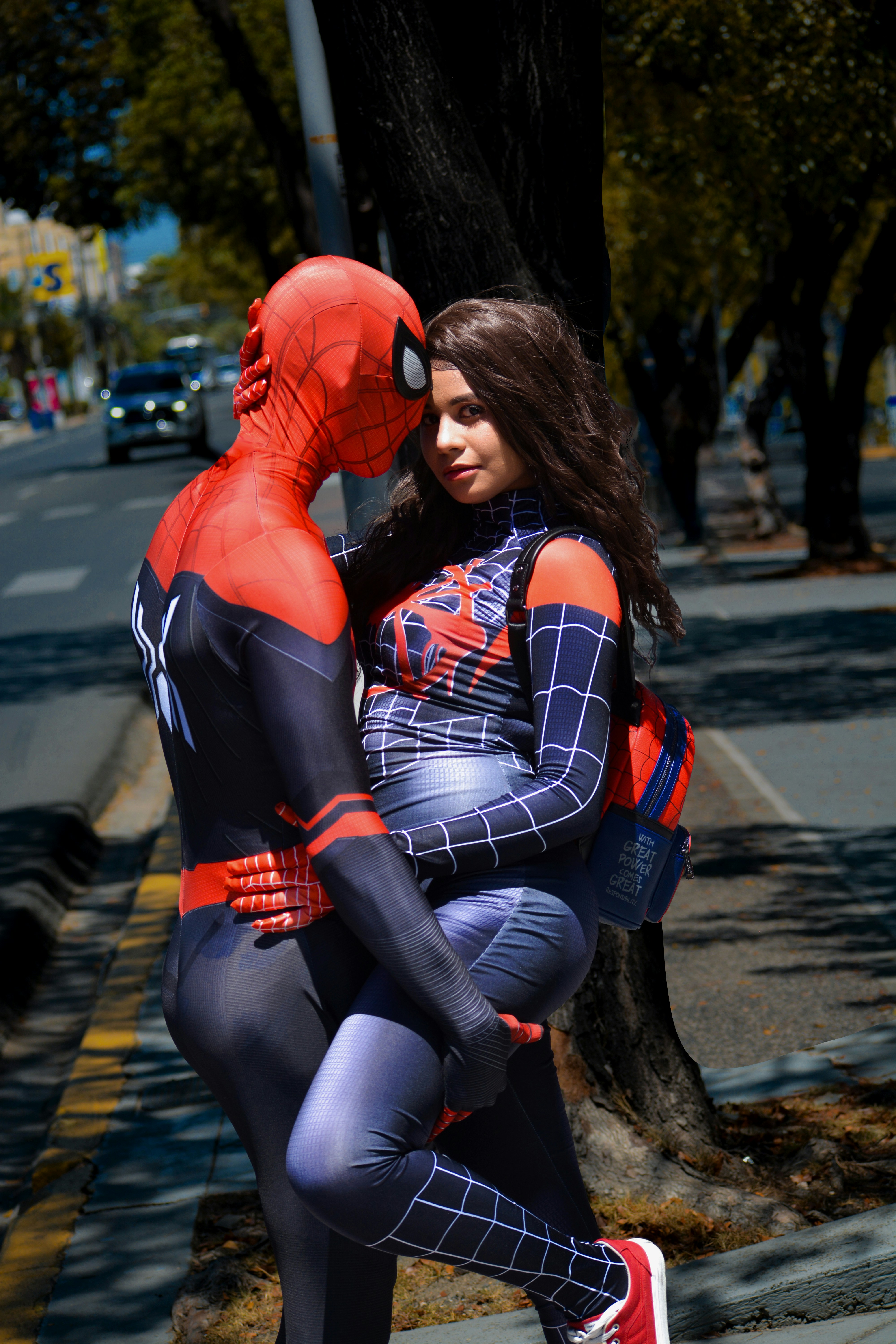 Seorang wanita dengan kostum spiderman memeluk seorang pria